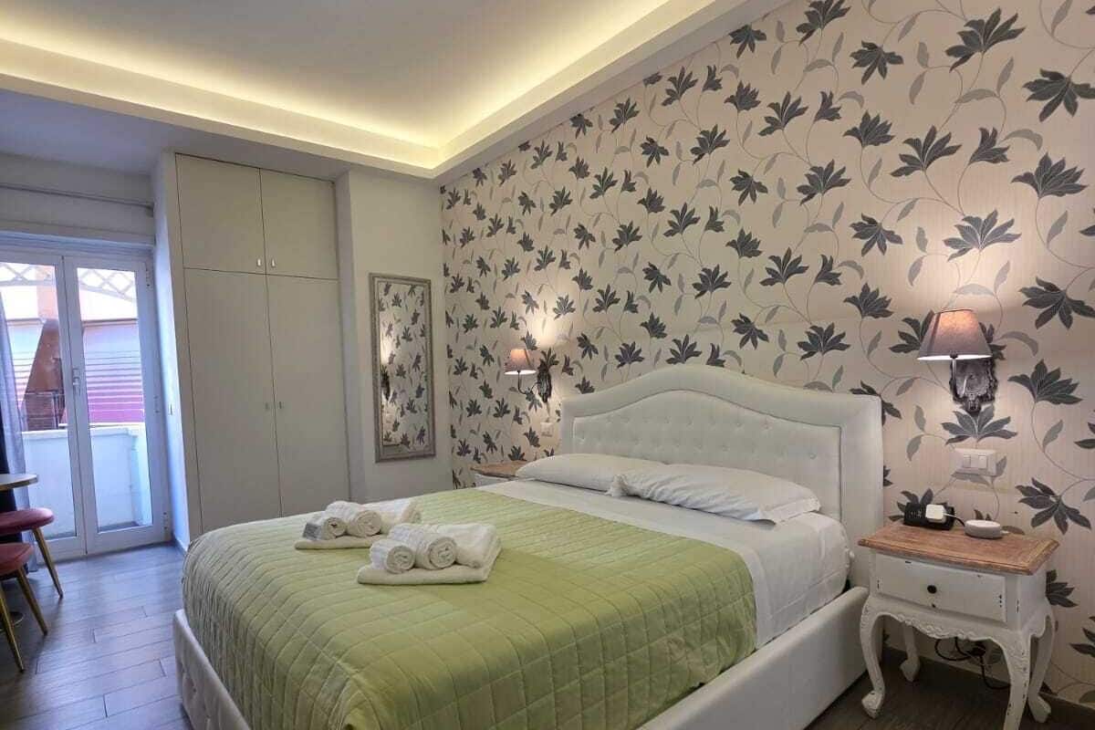 A neatly arranged bedroom with a bed, a bedside table, a lamp, and a wardrobe.
