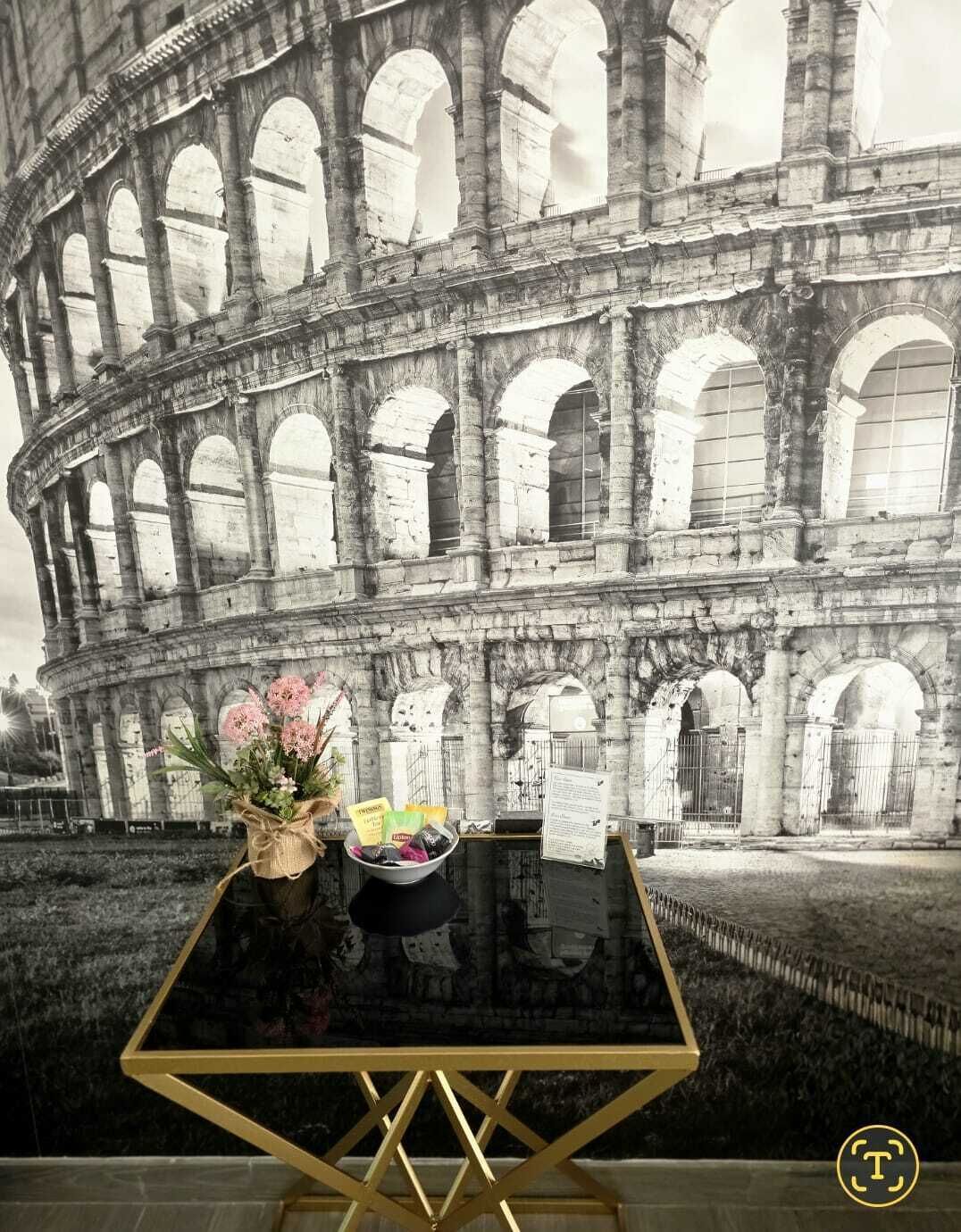 Una mesa con un florero y un cuenco frente al Coliseo.