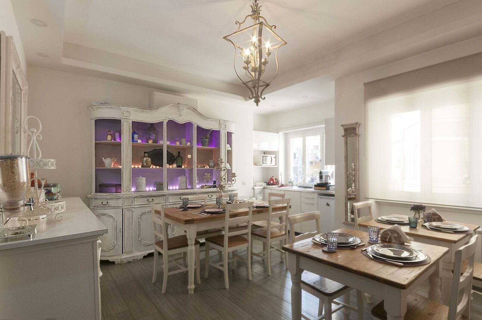A dining area with white cabinetry, a chandelier, and a window providing natural light.