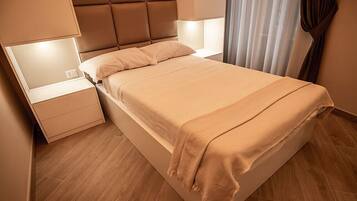 Ein modernes Schlafzimmer mit Bett, Nachttischen und einem Beistelltisch.