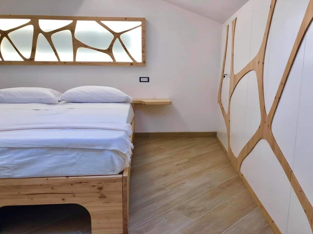 Une chambre à coucher avec un lit en bois, une étagère intégrée et un panneau mural en bois au design original.