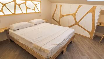 A bedroom with a wooden bed, a built-in wardrobe with a tree-like design, and a skylight above the bed.