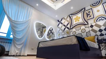 Ein modernes Schlafzimmer mit einem Bett, einem großen Fenster mit Vorhängen und einer Wand mit geometrischen Mustern.