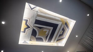 A ceiling with geometric patterns and recessed lighting.