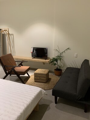 Habitació quàdruple Deluxe | Sala d'estar | Televisor de pantalla plana de 32 polzades amb canals per cable 