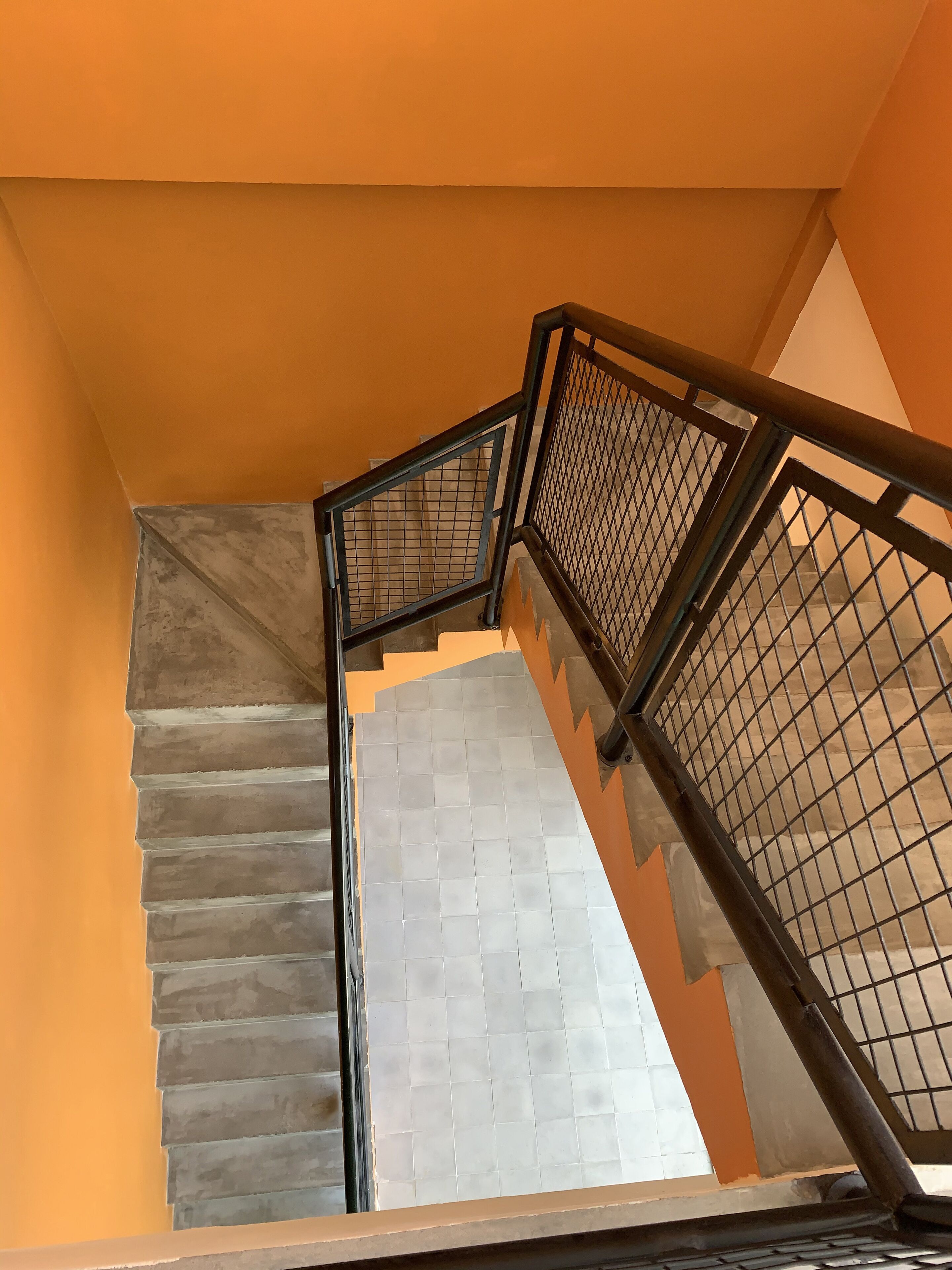 A staircase with metal railings and a tiled landing area.