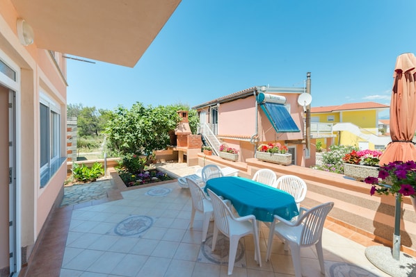 A patio with a table and chairs, a brick chimney, and a satellite dish.