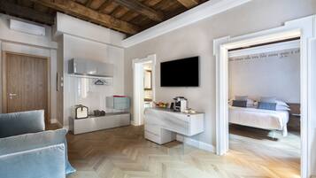 Ein modernes Schlafzimmer mit Bett, Nachttisch und einem an der Wand montierten Fernseher.