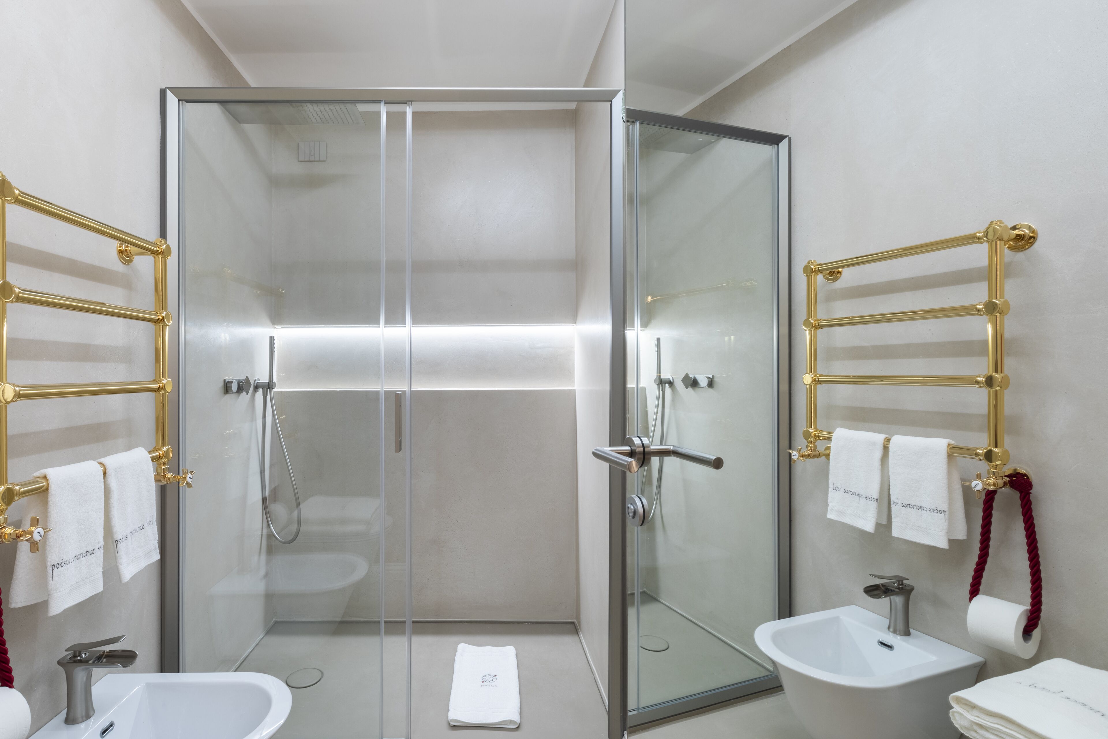 Un baño moderno con ducha envuelta en vidrio, un lavabo blanco y un bidé.