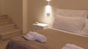 A hotel room with a bed, a nightstand, and a wall-mounted light.