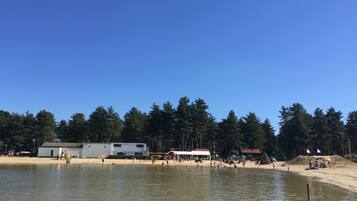 Aan het strand, ligstoelen aan het strand, parasols, beachvolleybal