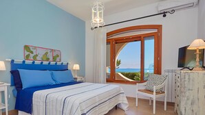 A bedroom with a bed, a chair, a TV, and a view of the sea. - Villa with direct sea access near Palermo (Carini)