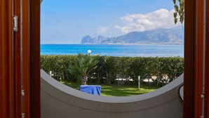 A circular window view of a coastal landscape with a clear sky, a mountain range, and a body of water. - Villa with direct sea access near Palermo (Carini)