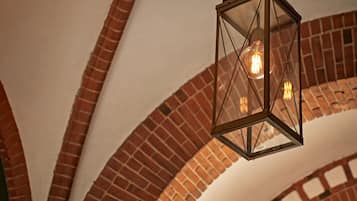 A hanging lantern with a visible light bulb inside, suspended from a chain.