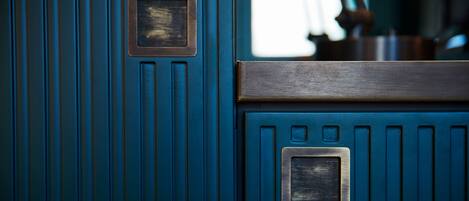 A close-up of a blue door with a metal handle and a rectangular metal plate.