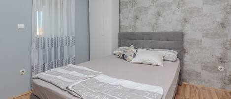 A bedroom with a bed, a wardrobe, and a curtain.
