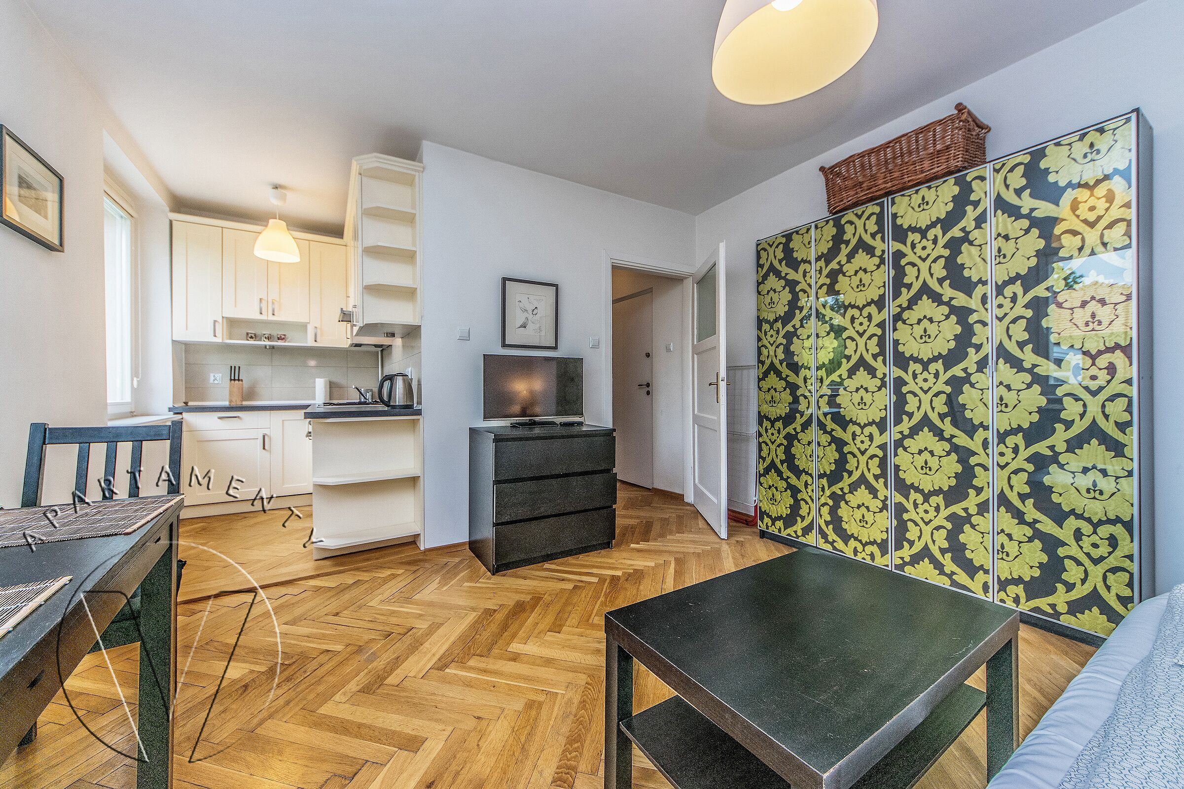 Un ambiente compatto con angolo cottura, zona pranzo e camera da letto.