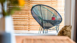 A room with a wooden slatted window, a chair, and a potted plant. - stuub langenbach (Titisee-Neustadt)