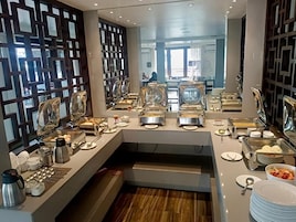 A buffet setup with multiple serving stations, including trays of food and various utensils.