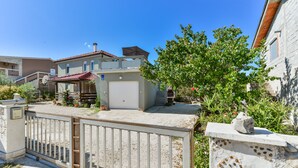 Un lotissement résidentiel fermé, avec une maison dotée d’un balcon, d’une antenne parabolique et d’un garage.