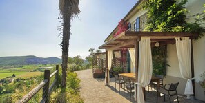 A patio with a table and chairs, overlooking a scenic landscape.