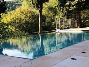 Una piscina al aire libre, sillones reclinables de piscina