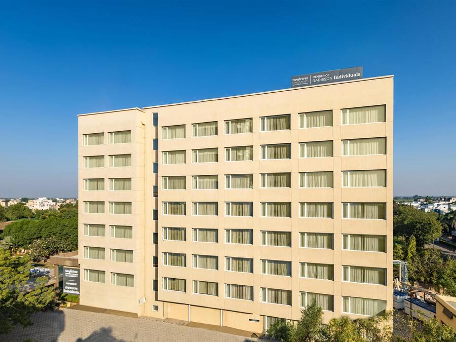 Un hotel de varias plantas con fachada color beige, numerosas ventanas y un letrero que indica membresía en la red Radisson.
