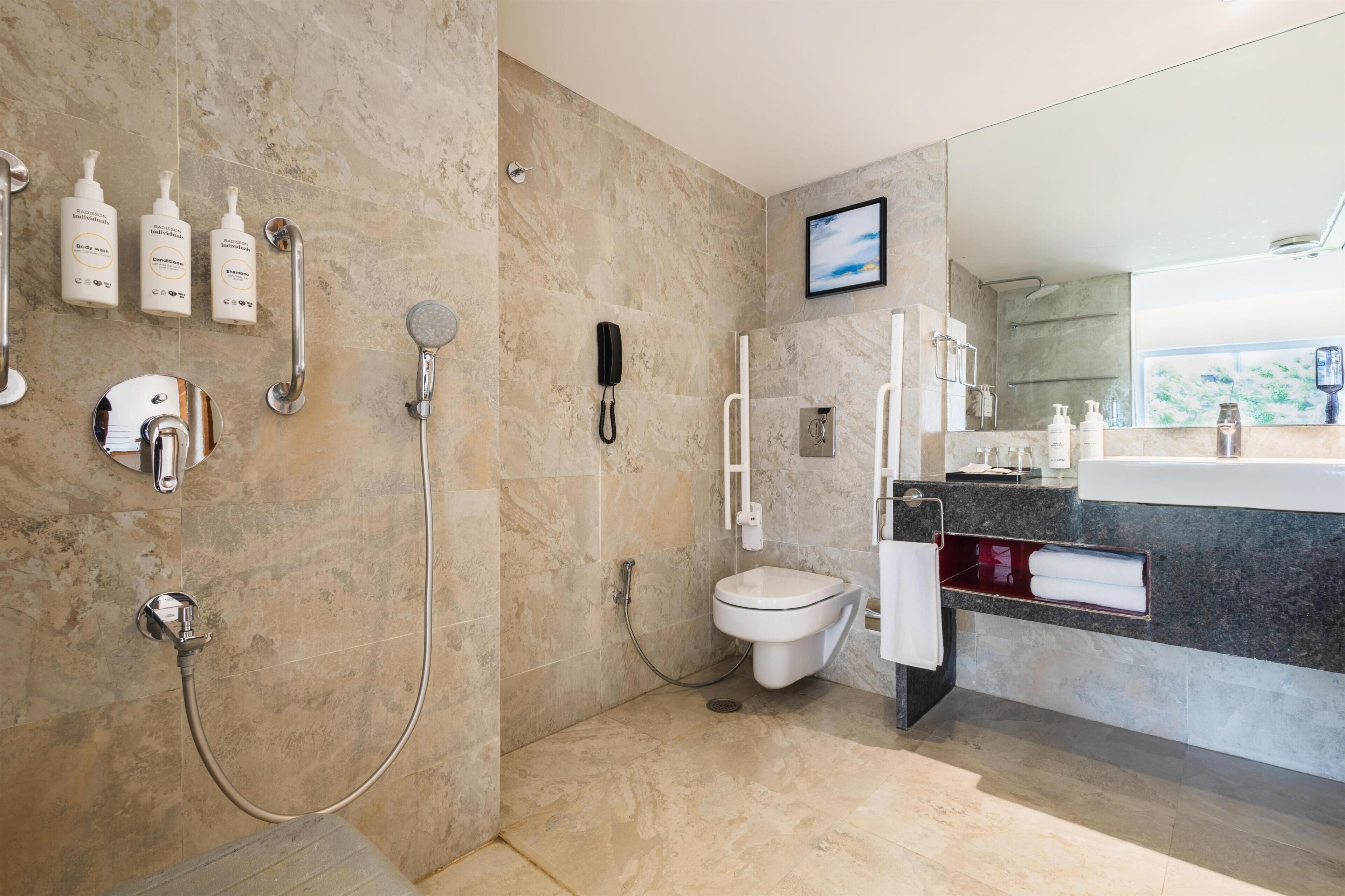 A modern bathroom with a shower, toilet, and vanity.