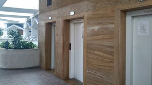 An interior corridor with three elevator doors labeled "Lift 2" and "Lift 3". - Kharadi EON IT NP Hospitality (Pune)