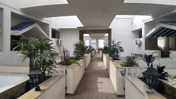 A corridor with potted plants and a tiled floor, leading to a staircase. - Kharadi EON IT NP Hospitality (Pune)