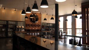 A modern bar area with pendant lighting, shelves of bottles, and a polished bar counter. - Hotel Vinícola Davo (Ribeirão Branco)