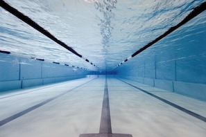 An underwater tunnel with clear water, concrete walls, and a central walkway. - Sportpark Rabenberg (Breitenbrunn/Erzgeb.)