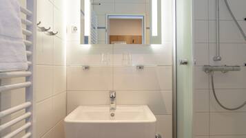 Shower, pengering rambut, handuk, dan tisu toilet