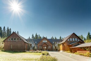 A large wooden building with a central entrance, two side wings, and a covered area with stairs. - Sportpark Rabenberg (Breitenbrunn/Erzgeb.)