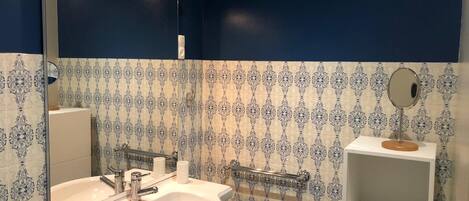 A bathroom with a white sink, a mirror, and a towel rack.