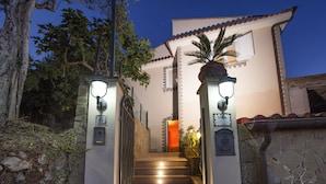 A staircase leading to a villa with a stone wall on one side and a tree on the other. - Villa Felice (Massa Lubrense)