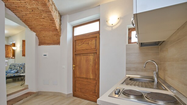 Una cocina con puerta de madera, un lavamanos y una estufa.