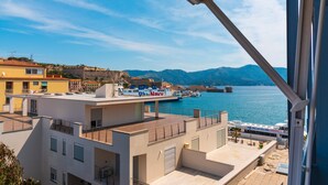 A coastal building with a rooftop terrace overlooking a marina with boats. - Appartamento Porto Mediceo (Portoferraio)