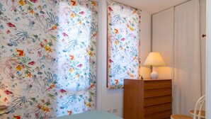A bedroom with a bed, a dresser, a chair, and a lamp. - Appartamento Porto Mediceo (Portoferraio)