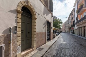 Ruas de pedra com um edifício que possui uma grande entrada em arco e uma placa indicando um restaurante.