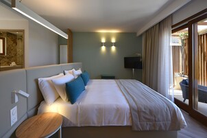 Habitación de hotel con una cama grande, mesitas de noche, un televisor de pantalla plana y vistas al exterior.