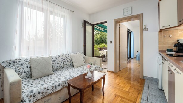 A living room with a sofa, a coffee table, and a view to the outside. - Funtana Apartments Budinjaš  (FUNTANA)