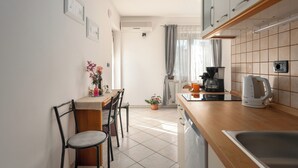 A compact kitchen with a wooden countertop, a sink, a coffee maker, and a potted plant. -  Funtana Apartments Budinjaš  (FUNTANA)