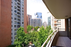 Residents enjoy balconies with railings, overlooking a lush urban landscape.