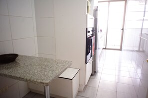 Kitchen features a granite countertop, stainless steel appliances, and a small cabinet.