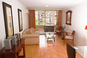 Relax in this stylish living room with a comfortable sofa, dining area, and large windows offering a view of the surrounding buildings.