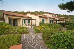 A row of Mediterranean-style villas with stone pathways and lush greenery.