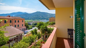 A balcony with a view of a mountain, a road, and buildings. - Appartamento Elisa (Portoferraio)