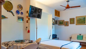 A compact room with a bed, a small table, and a TV mounted on the wall. - Appartamento La Via Del Mare (Rio)