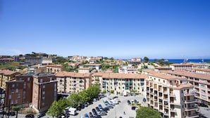 Zona residencial con edificios de varios pisos, un estacionamiento y vista despejada al mar.